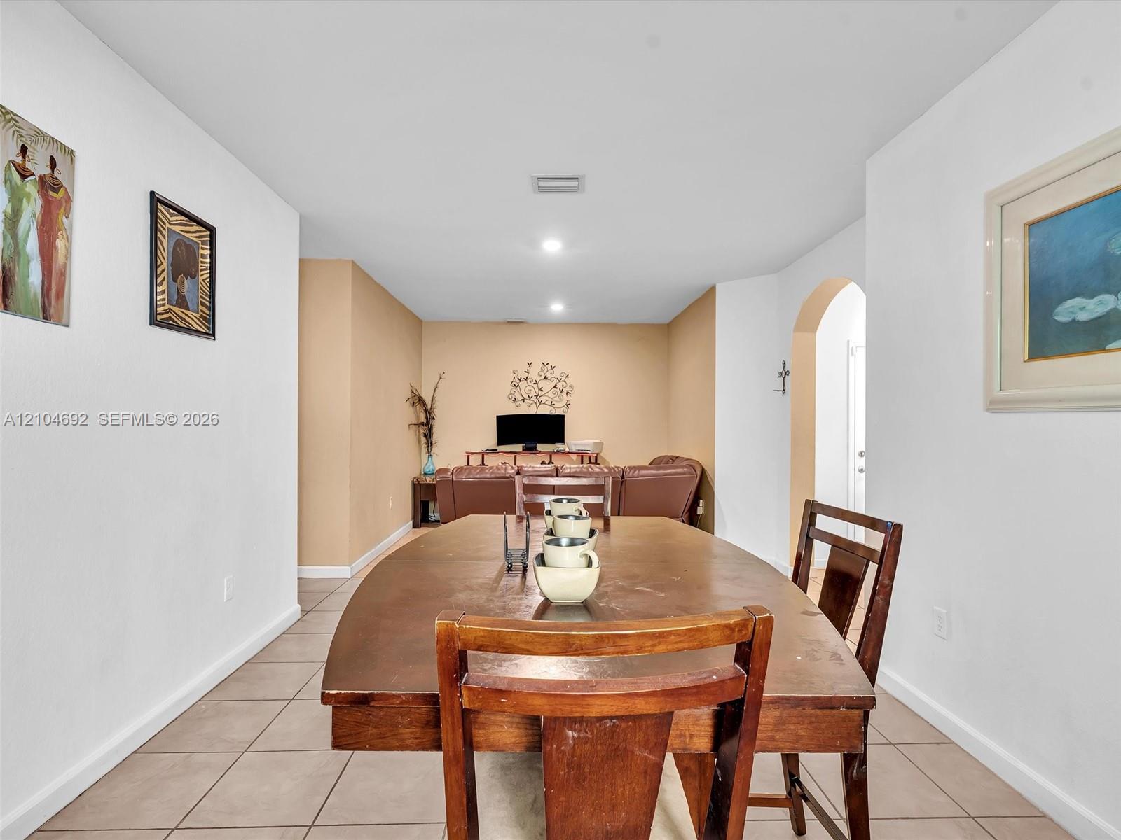Neutral-toned interior featuring ceramic tile flooring, recessed lighting, and a decorative arched entryway Neutral-toned interior featuring ceramic tile flooring, recessed lighting, and a decorative arched entryway