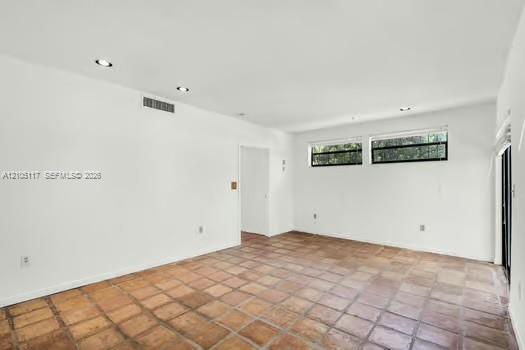 Interior space featuring terracotta-style tile flooring, recessed lighting, and horizontal windows