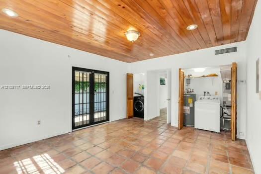Interior space featuring terra cotta tile flooring, vaulted wood-plank ceiling, recessed lighting, and dual French doors with black frames