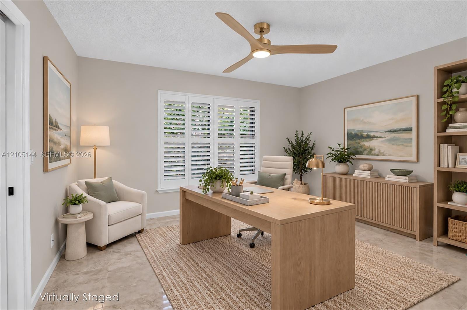 Neutral-toned walls, three-blade wood-finish ceiling fan with integrated lighting, polished stone-finish flooring, and white plantation shutters