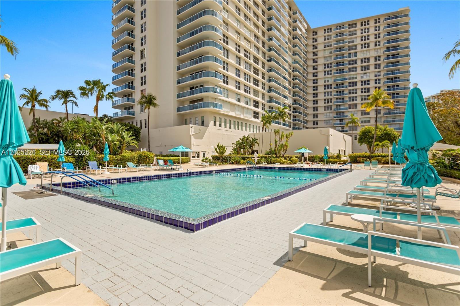 Concrete deck with tile grid detailing, white perimeter railing, and waterfront orientation