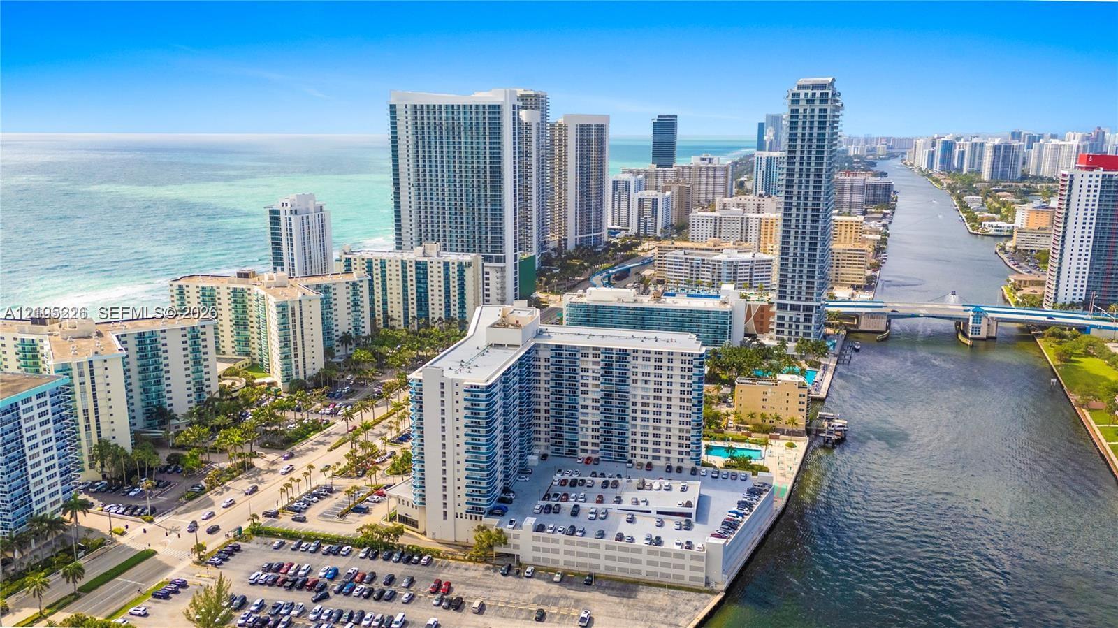 Aerial coastal perspective featuring a multi-story high-rise building, deep-water canal frontage, and proximity to the Atlantic shoreline