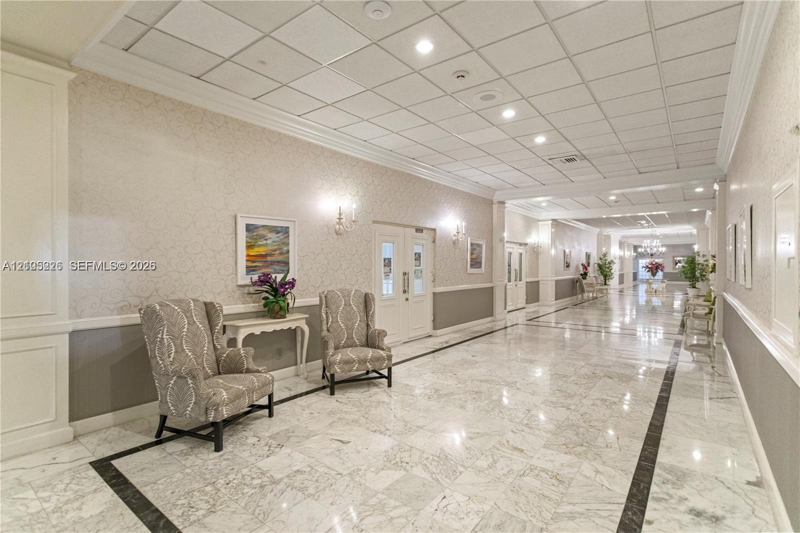 Recessed ceiling lighting, patterned wall-to-wall carpeting, two-toned wall finishes with chair rail molding, and a suspended stained-glass style pendant light