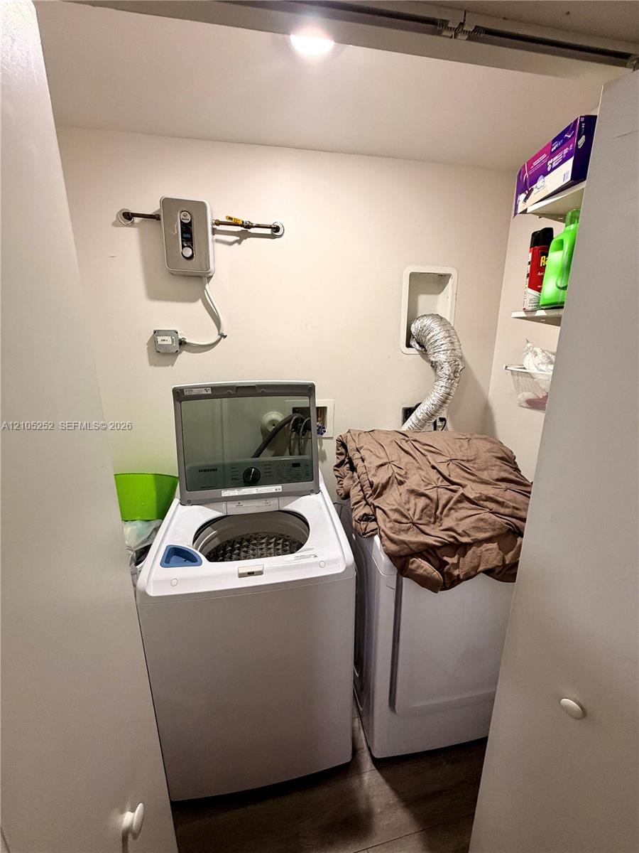 Dedicated laundry area with wood-finish flooring and built-in shelving