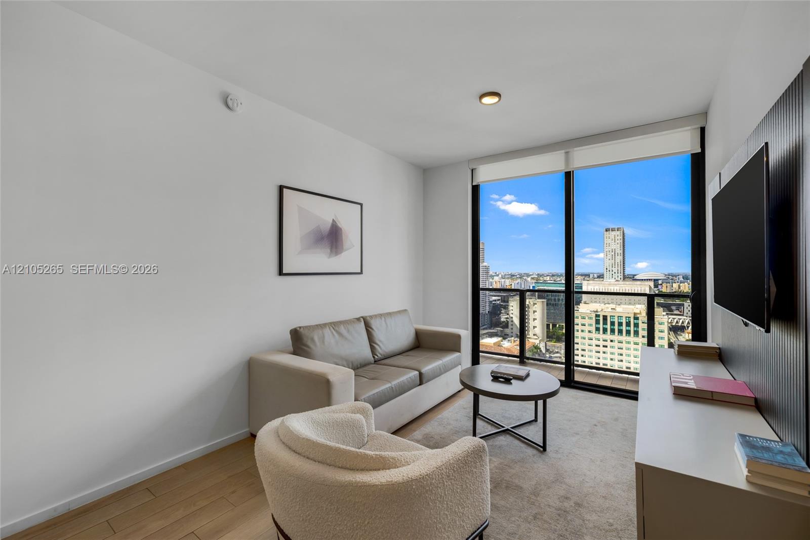 Floor-to-ceiling windows, wood-finish flooring, and built-in vertical slat paneling