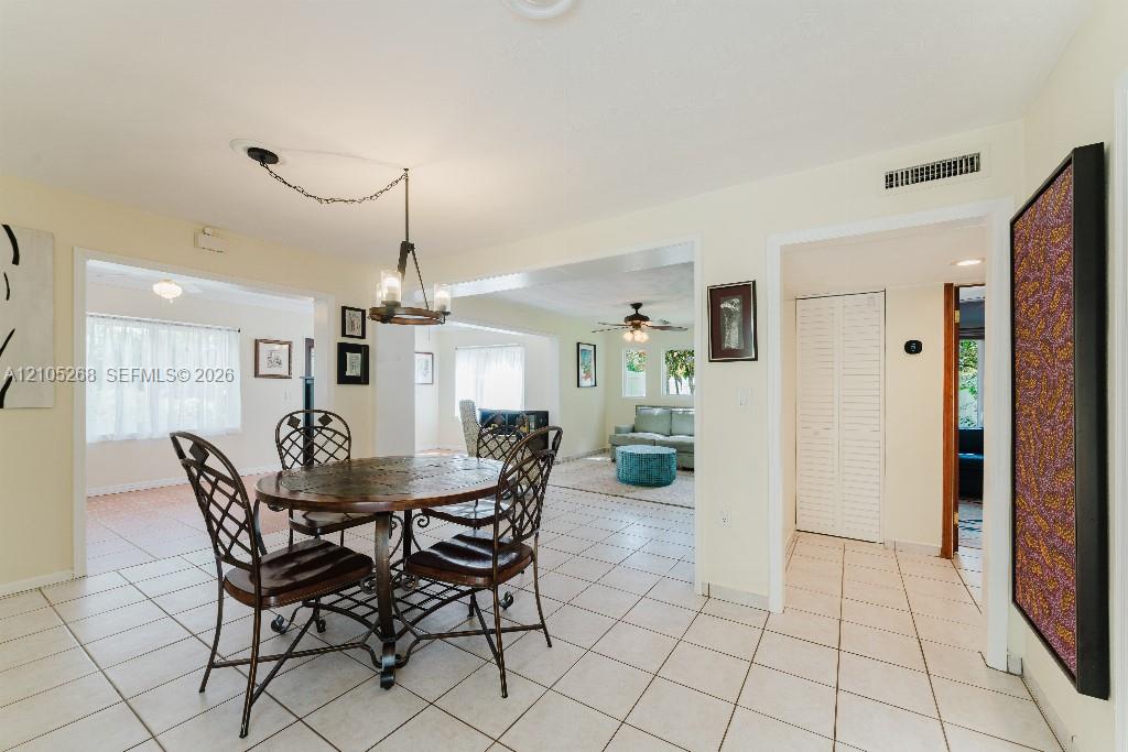 Tile flooring extends throughout this space, featuring an exposed beam ceiling and recessed lighting