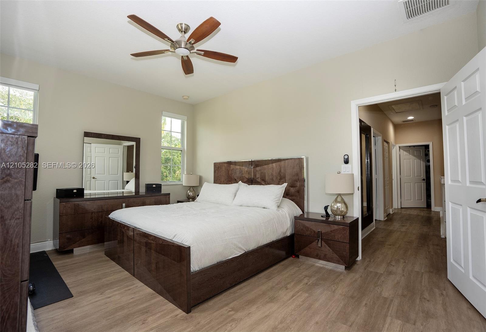 Vaulted ceilings, wood-finish flooring, multi-pane windows, and a ceiling fan with integrated lighting