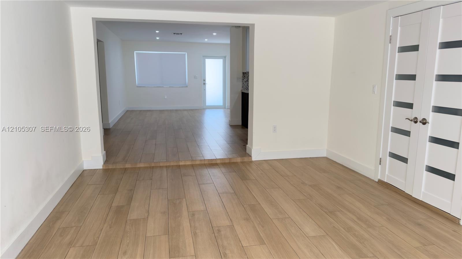 Wood-finish flooring throughout, recessed ceiling lighting, and double-door entry featuring glass horizontal panels Wood-finish flooring throughout, recessed ceiling lighting, and double-door entry featuring glass horizontal panels