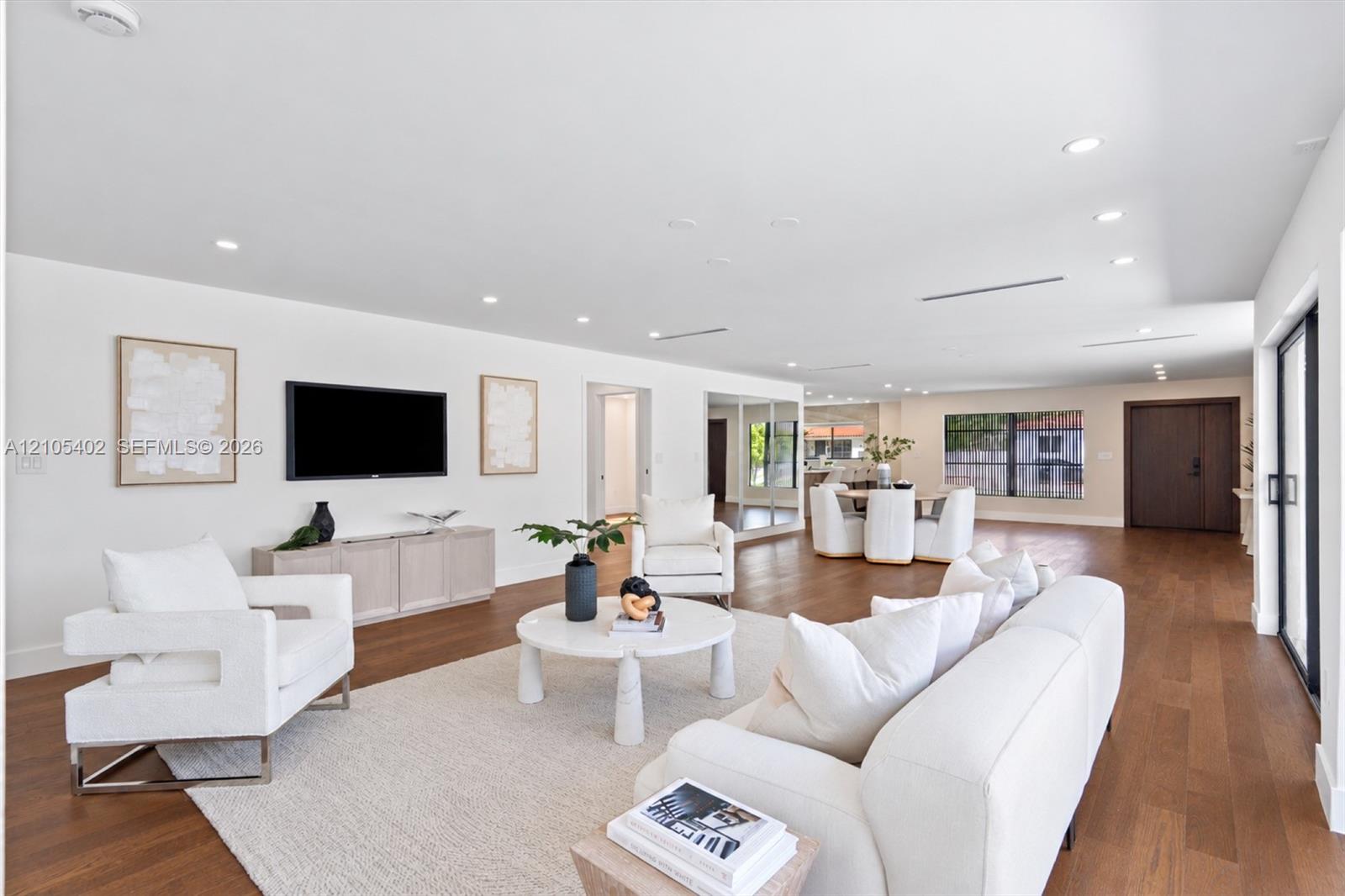 Open-concept floor plan featuring wood-finish flooring, recessed lighting, neutral interior palette, and sliding glass doors
