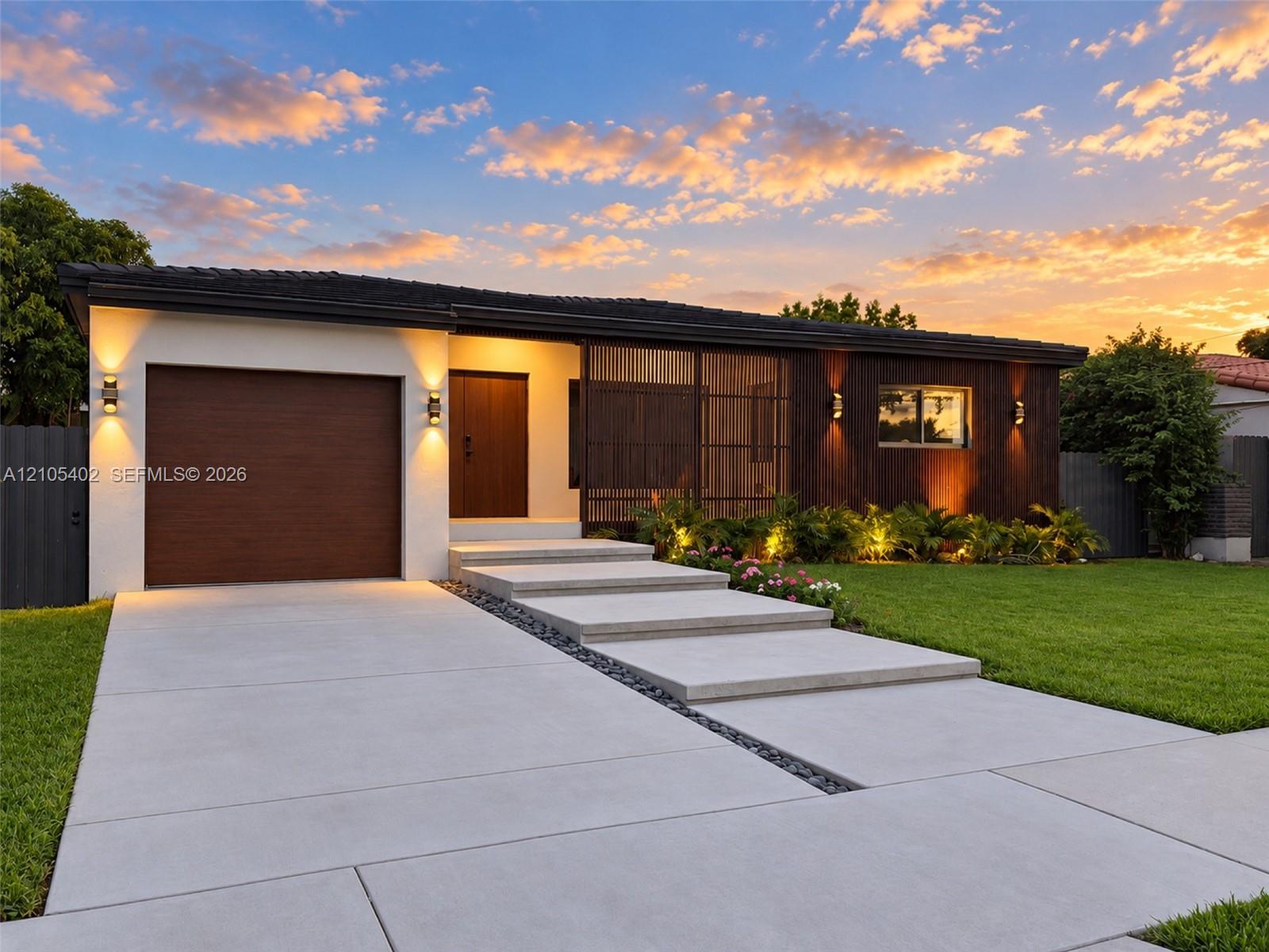 Modern exterior featuring a combination of stucco and wood-finish cladding, single-car garage, integrated screen paneling, and concrete slab walkway with stone accent border