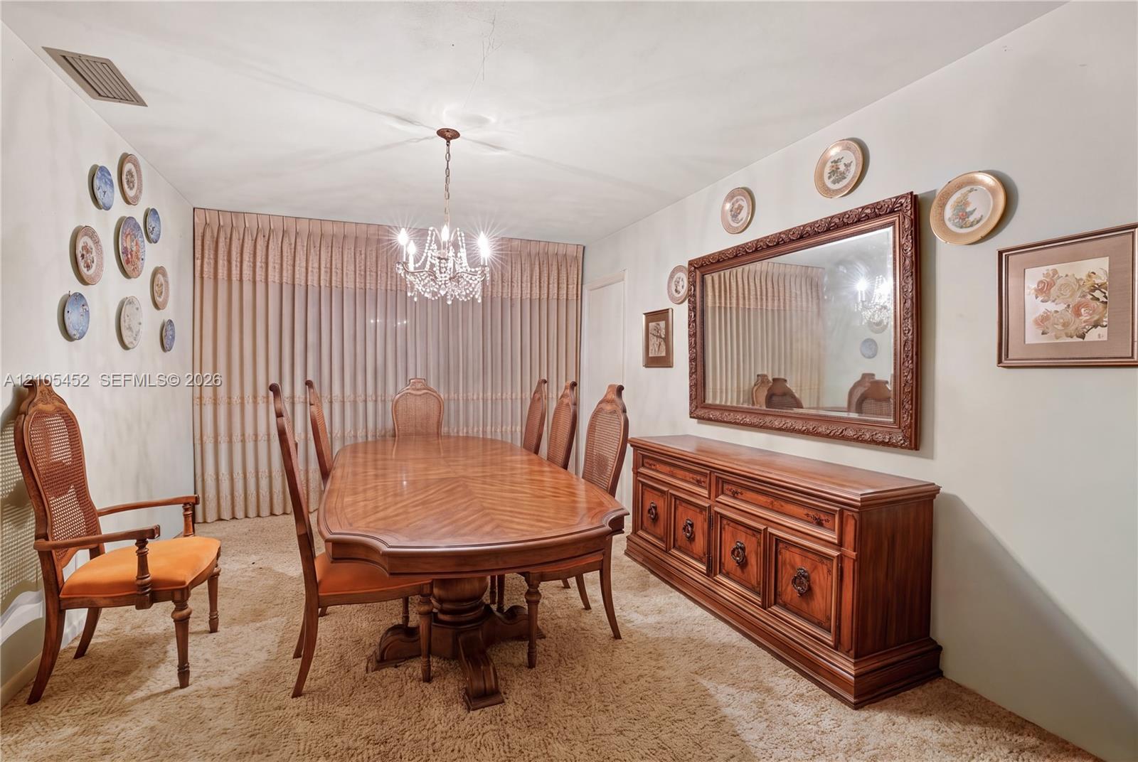 Multi-arm crystal chandelier and wall-to-wall pleated window drapery