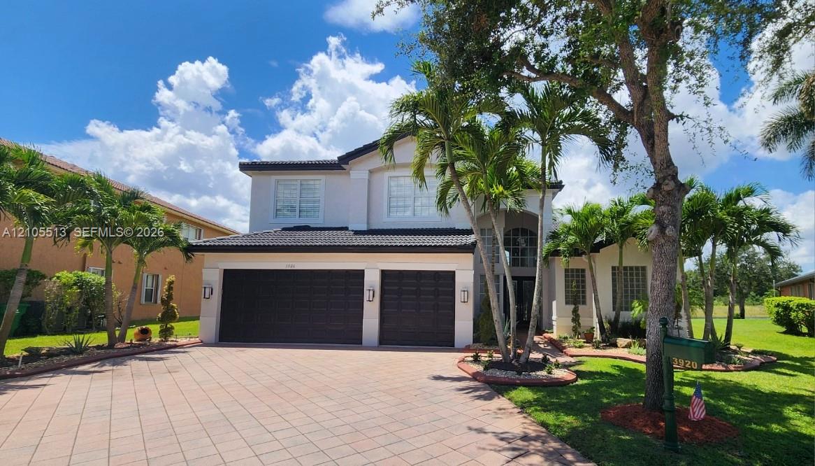 Front view with professional landscape, 3-car garage & 6-car driveway