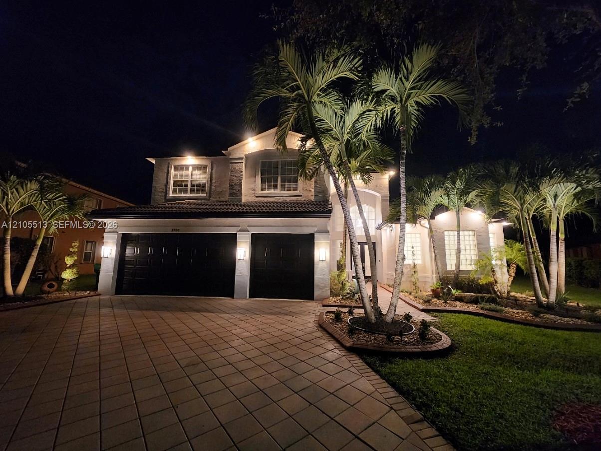 Night view of front with custom exterior automated lighting package