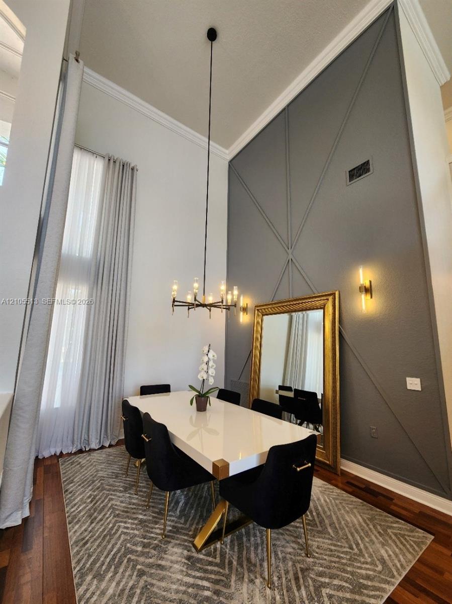 Dramatic 20ft accent wall with geometric molding, modern chandelier & wall sconces