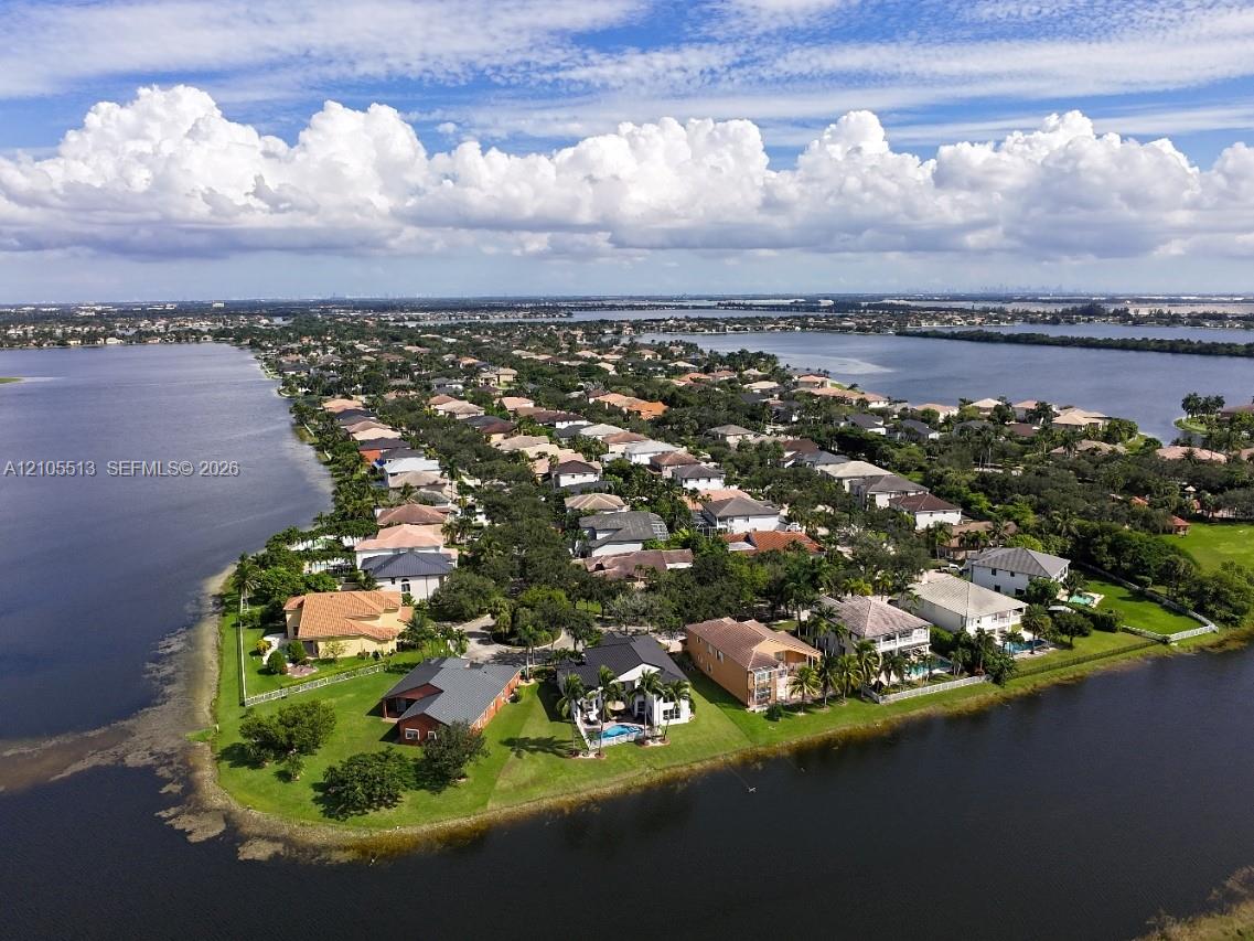 Lakeside community featuring a variety of architectural styles, mature trees, and waterfront properties
