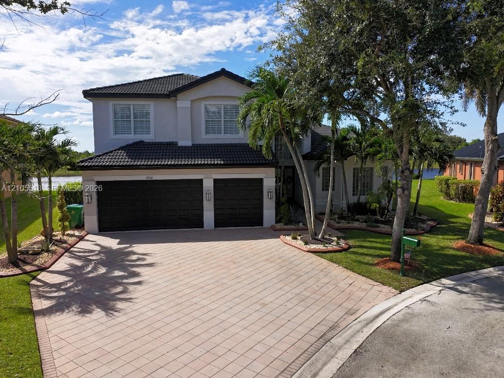 Two-story residence featuring a tile roof and a 3-car garage w/driveway parking for 6 cars