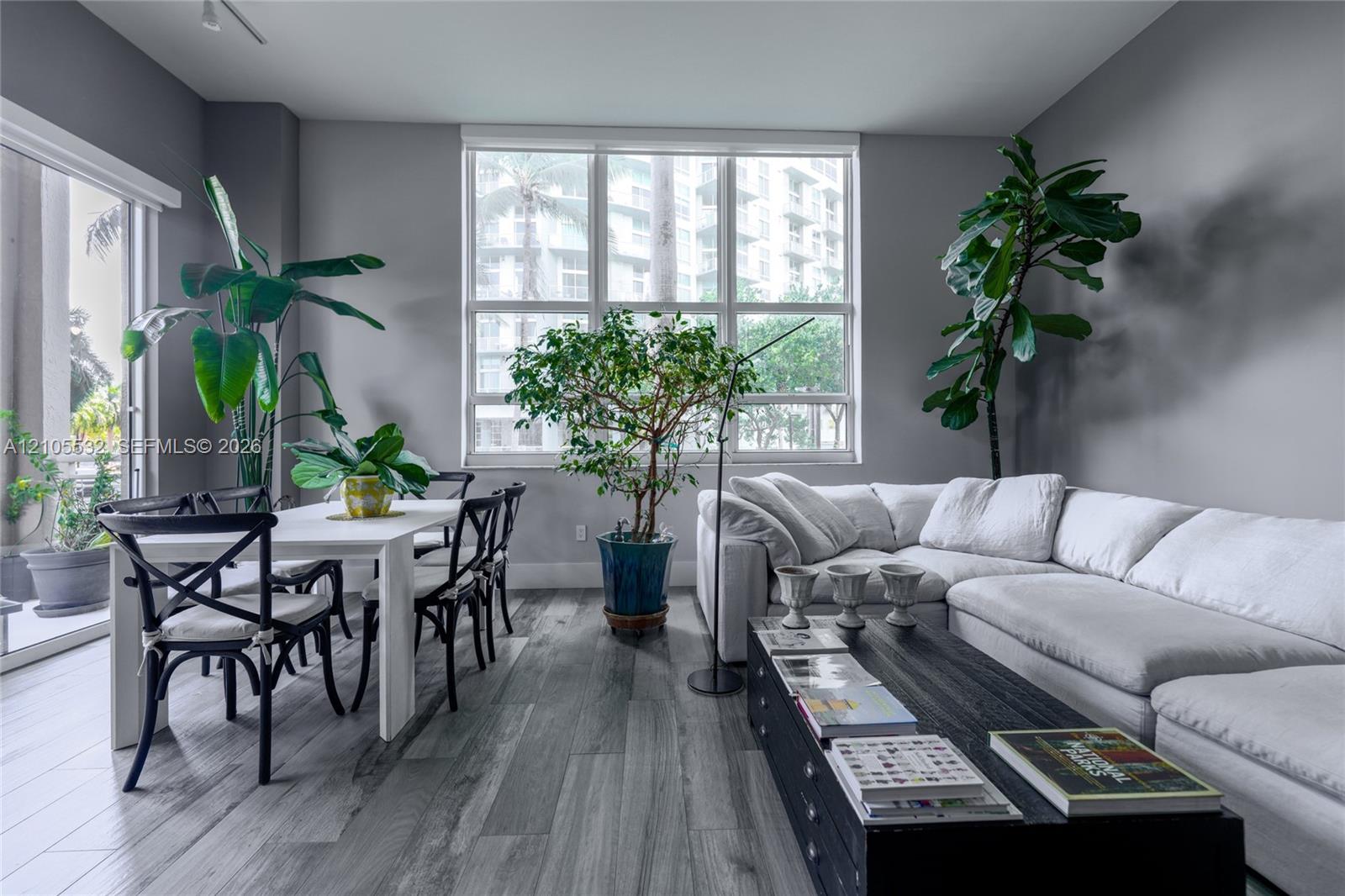 Living area featuring wood-finish flooring, floor-to-ceiling windows, and access to an exterior terrace