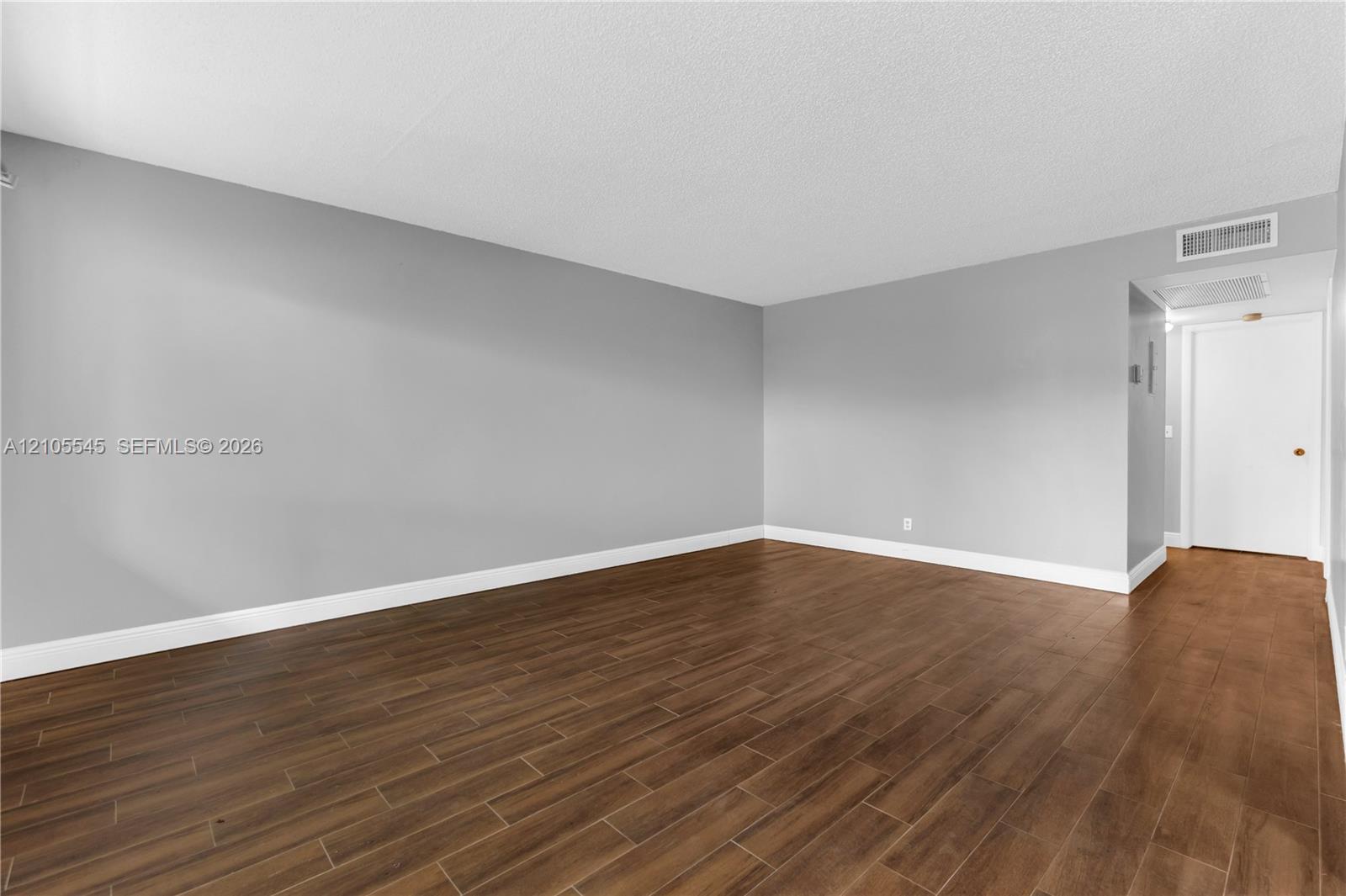 Wood-finish ceramic flooring throughout, complemented by neutral gray wall tones and crisp white trim