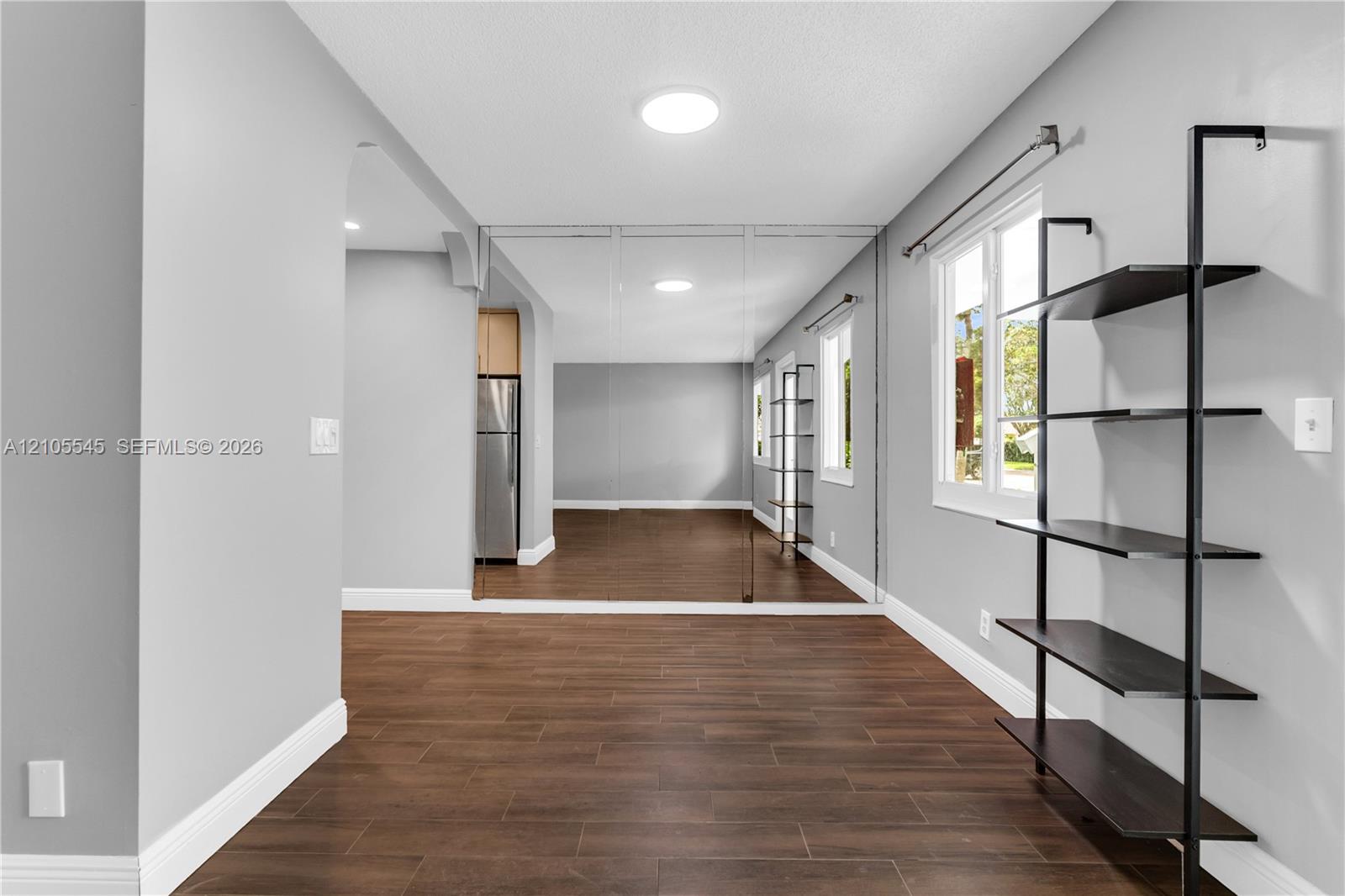 Recessed lighting, full-height wall mirror, wood-finish flooring, built-in shelving, and white trim