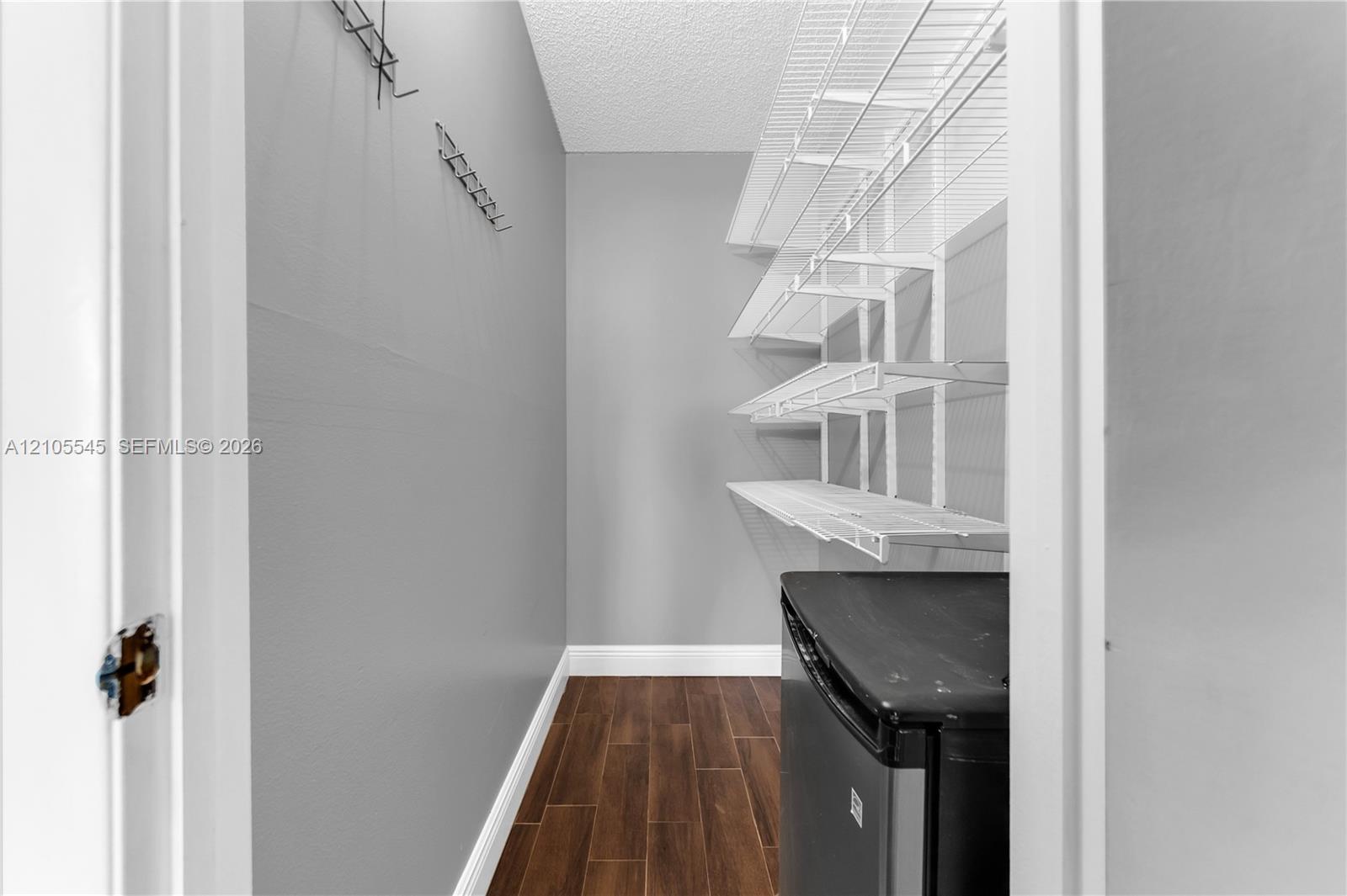 Wood-finish flooring with white trim, complemented by light gray walls