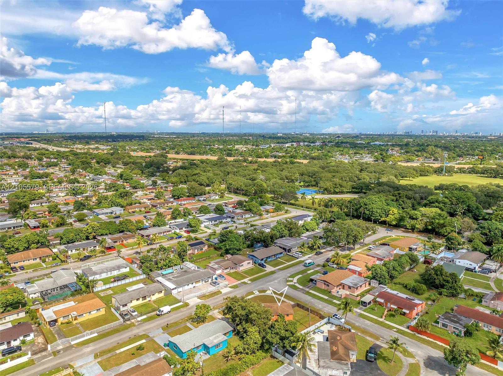 Aerial perspective featuring a single-story residence situated on a corner lot with mature landscaping and a fenced perimeter
