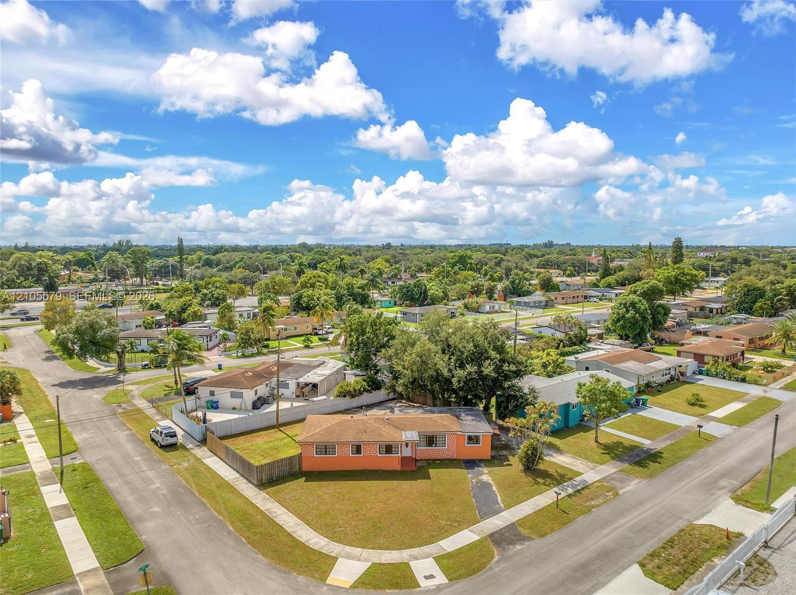 Corner lot residence featuring a paved driveway, exterior stucco finish, and a shingle roof