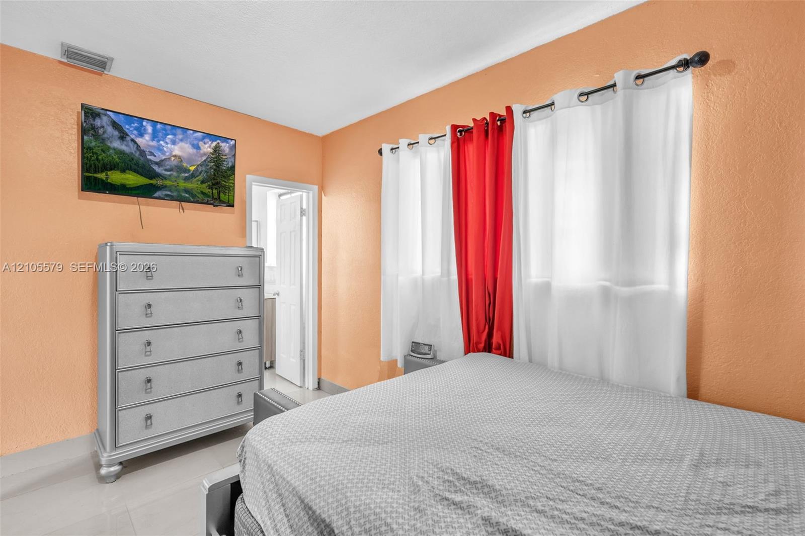 Room featuring neutral-toned walls, tiled flooring, and a multi-panel interior door