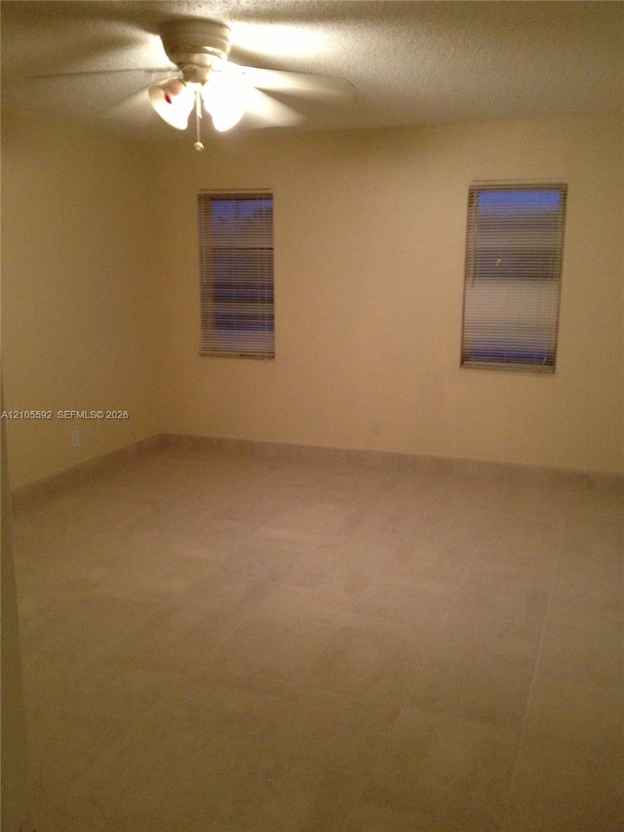 Recessed windows with blinds, ceiling fan with integrated lighting, and tile flooring