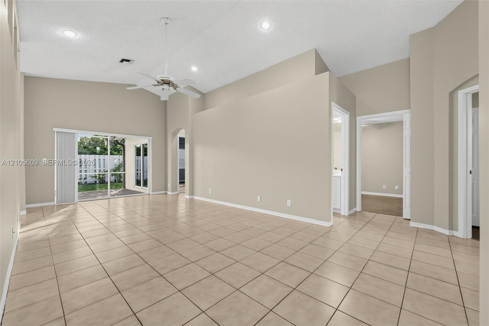 Interior space featuring vaulted ceilings, tile flooring, recessed lighting, a ceiling fan, and sliding glass doors Interior space featuring vaulted ceilings, tile flooring, recessed lighting, a ceiling fan, and sliding glass doors