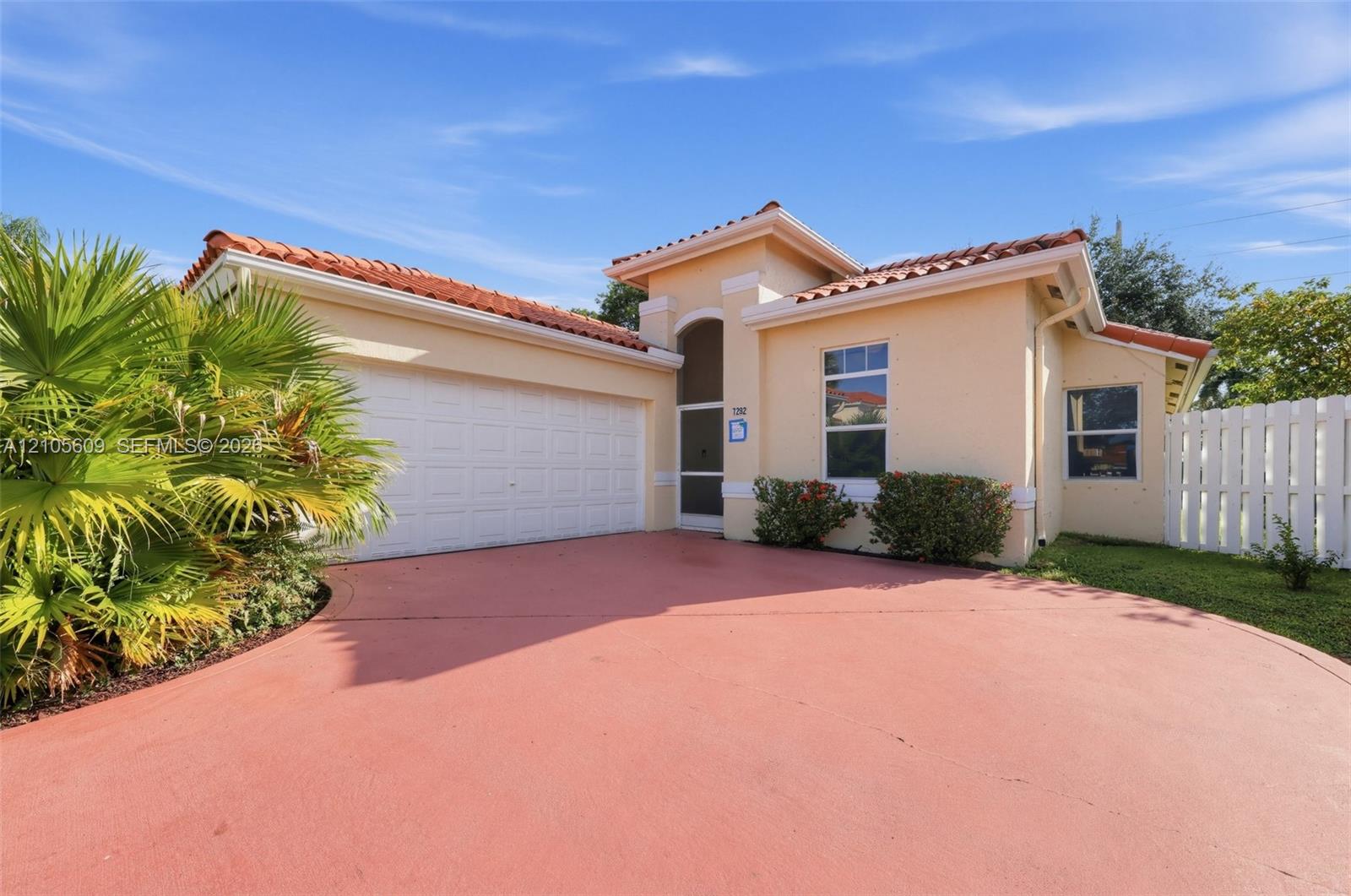 Single-story residence featuring a terracotta-tiled roof, stucco exterior, two-car garage, and screened entryway Single-story residence featuring a terracotta-tiled roof, stucco exterior, two-car garage, and screened entryway
