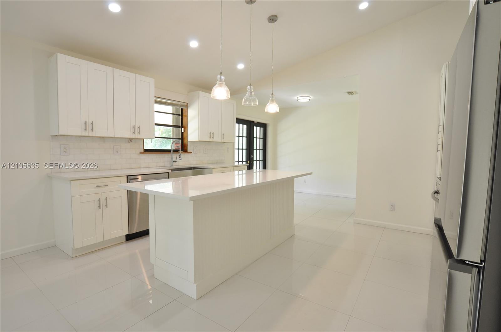 Kitchen featuring white cabinetry, quartz countertops, a central island, recessed lighting, and stainless steel appliances