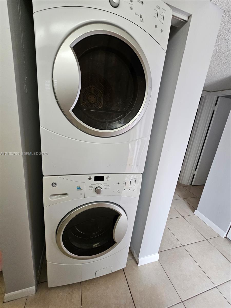 Stacked white front-load washer and dryer unit with metallic trim Stacked white front-load washer and dryer unit with metallic trim