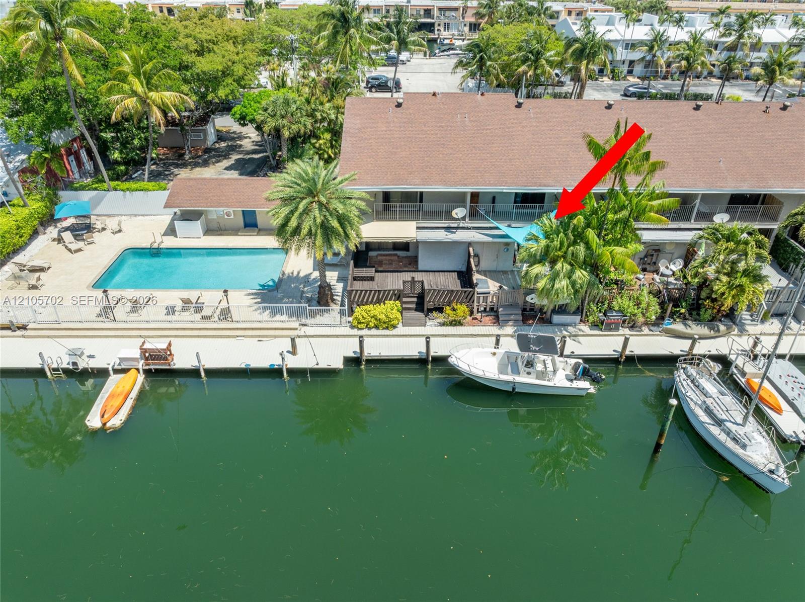 Waterfront property featuring a private boat slip, dockage, swimming pool, and wood-finish deck