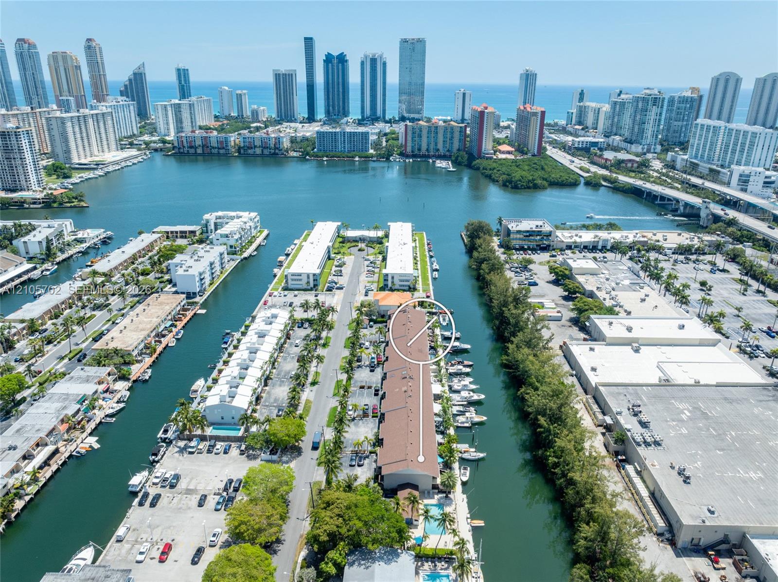 Aerial perspective featuring a waterfront building with dedicated boat slips, direct waterway access, and a surface parking lot