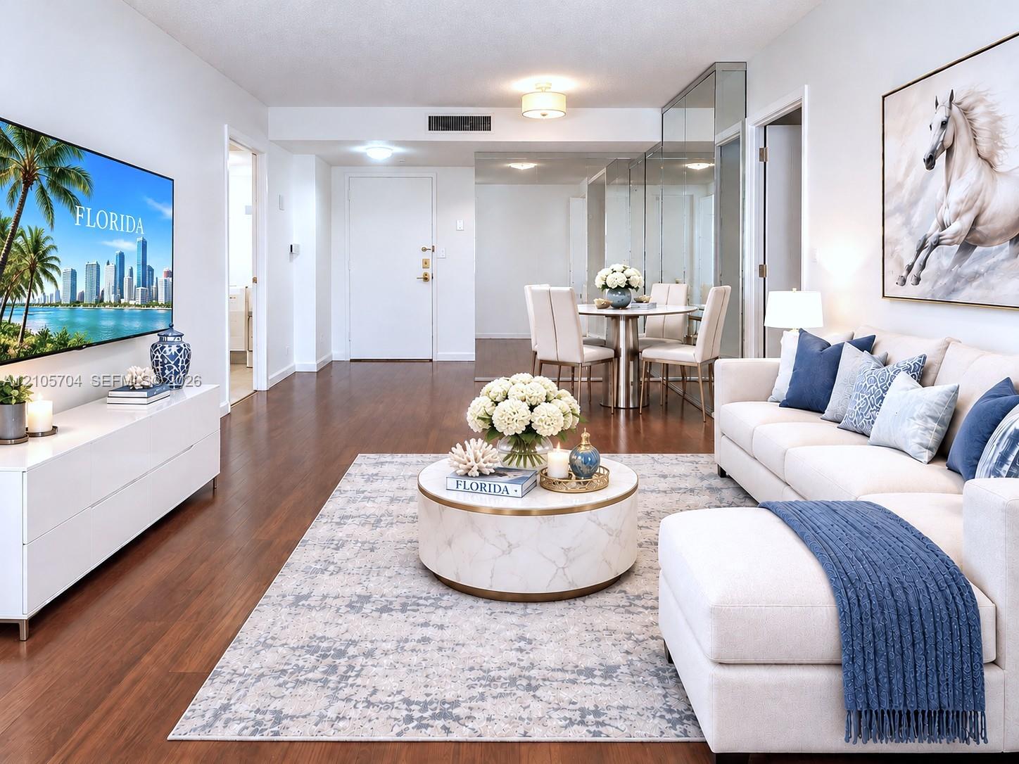 Open living area featuring wood-finish flooring, mirrored wall accents, and recessed lighting