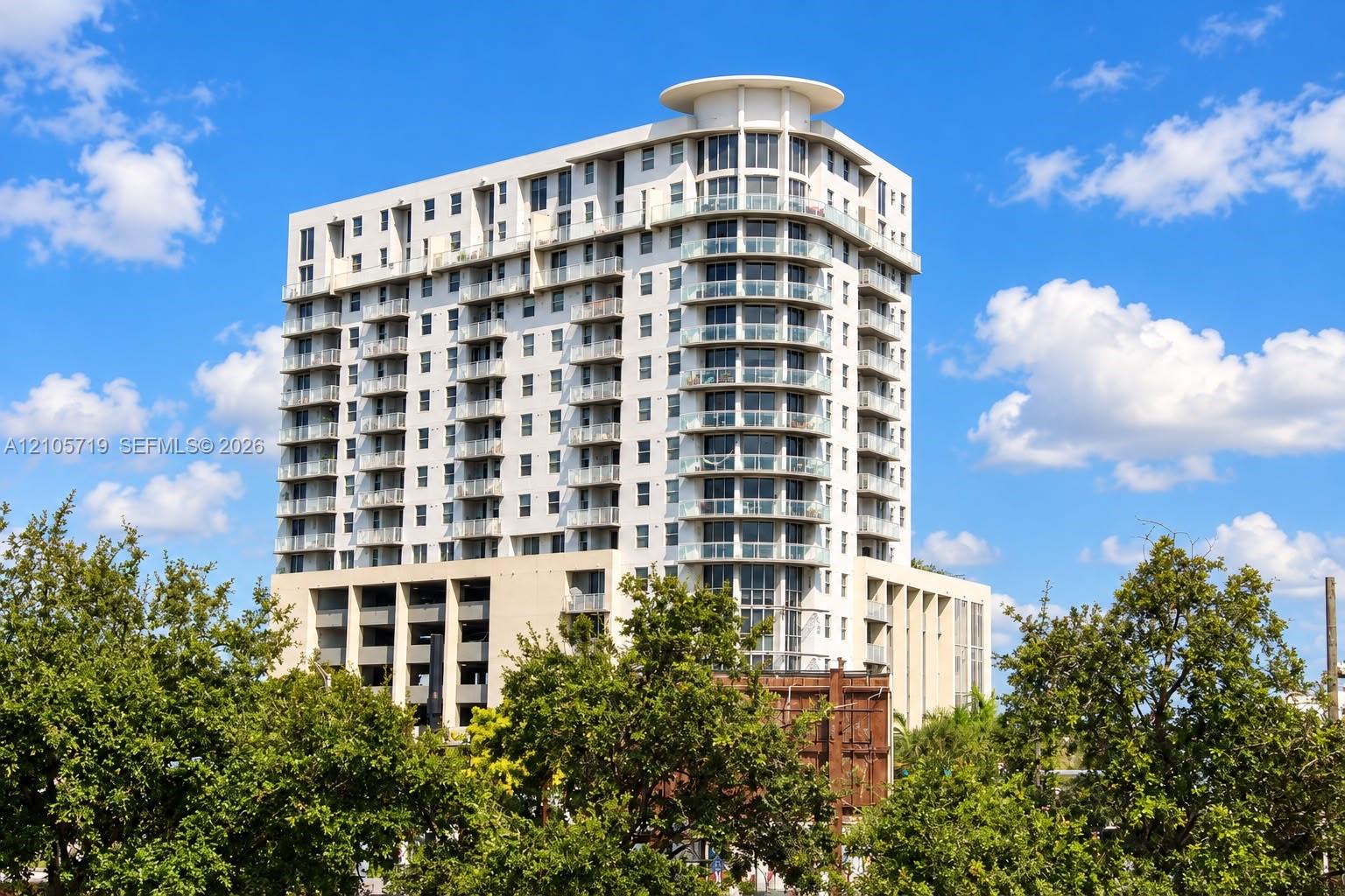 Modern residential tower featuring curved architectural lines, extensive glazing across multiple stories, and a rounded corner design