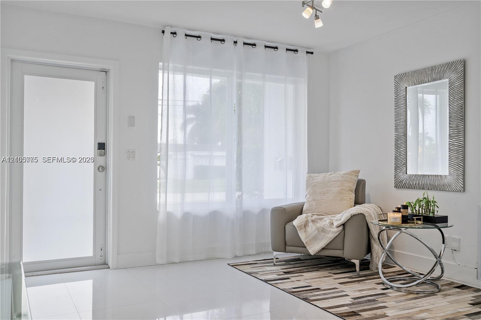 Entryway featuring high-gloss tile flooring, a glass-panel exterior door, a multi-light ceiling fixture, and a large window