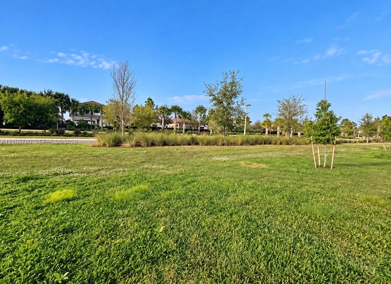 Expansive parcel featuring open green space, manicured grass, and mature landscape plantings