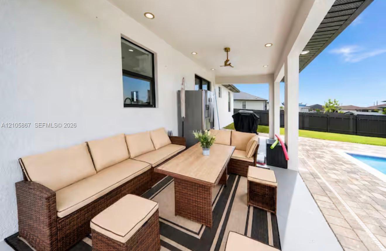 Covered patio featuring recessed ceiling lighting, a mounted ceiling fan, smooth finished walls, and concrete flooring Covered patio featuring recessed ceiling lighting, a mounted ceiling fan, smooth finished walls, and concrete flooring