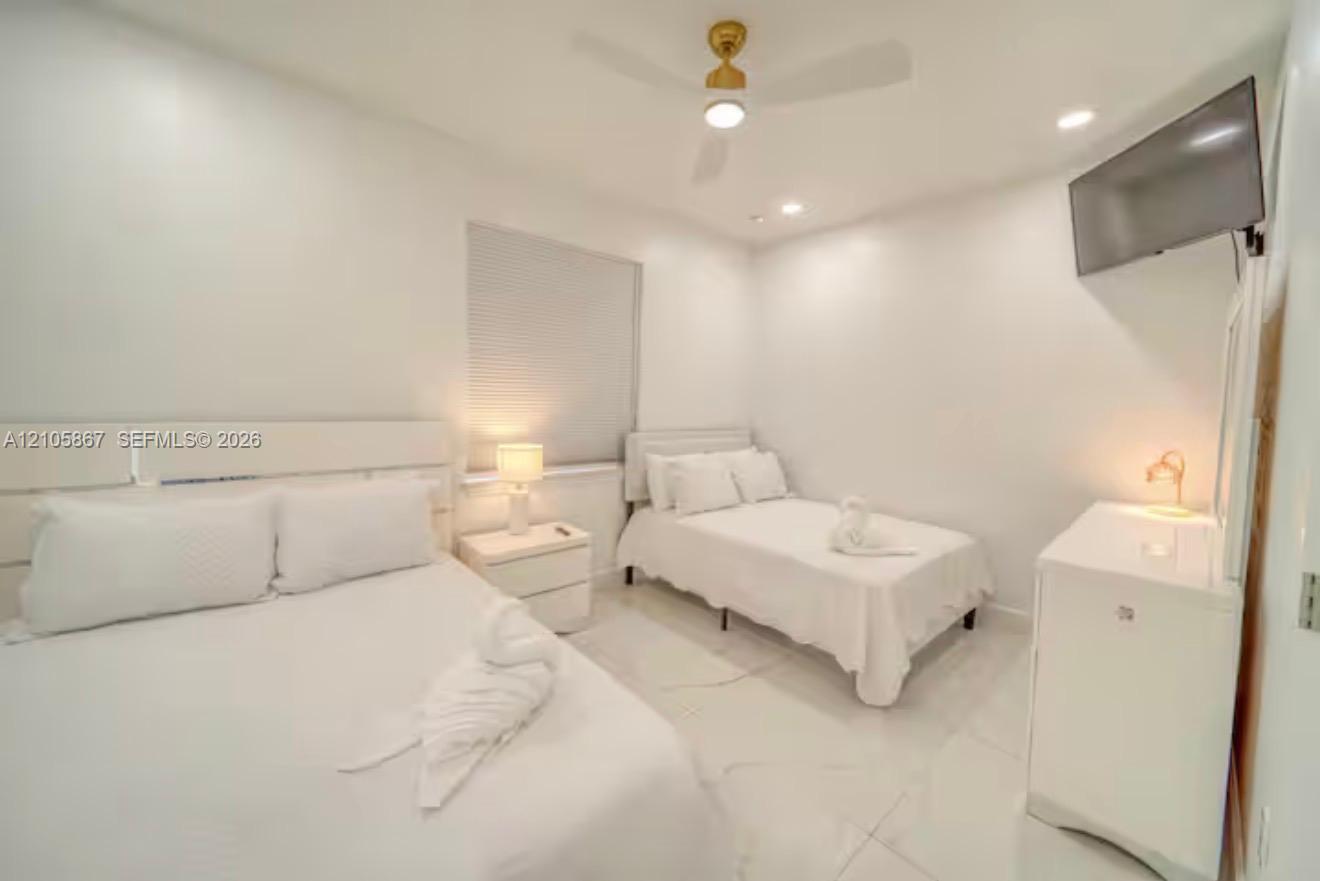 Large-format tile flooring, recessed lighting, and an overhead ceiling fan