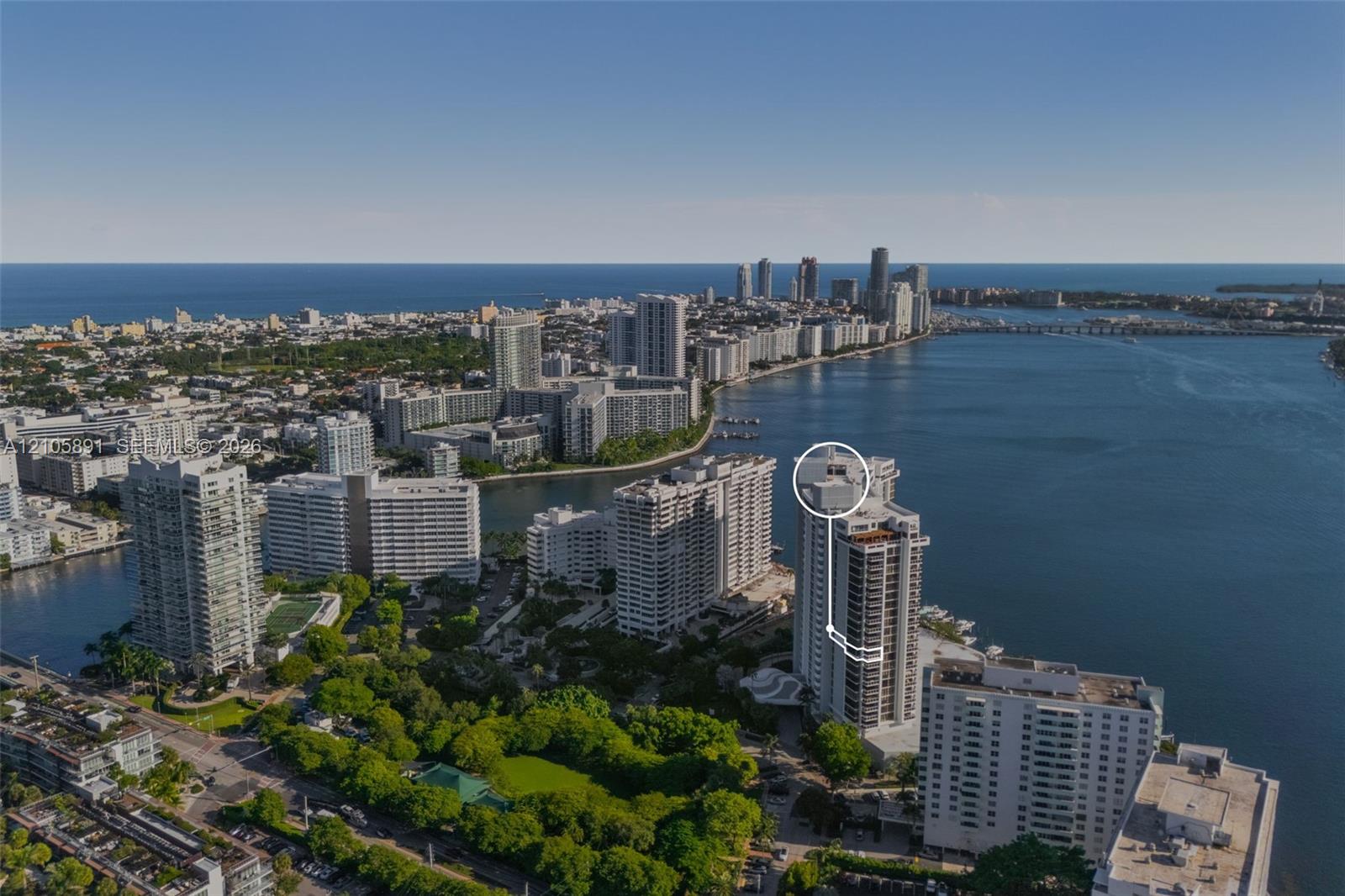 Aerial perspective of coastal high-rise residence featuring direct water frontage, proximity to the coastline, and a prominent position within a dense urban landscape