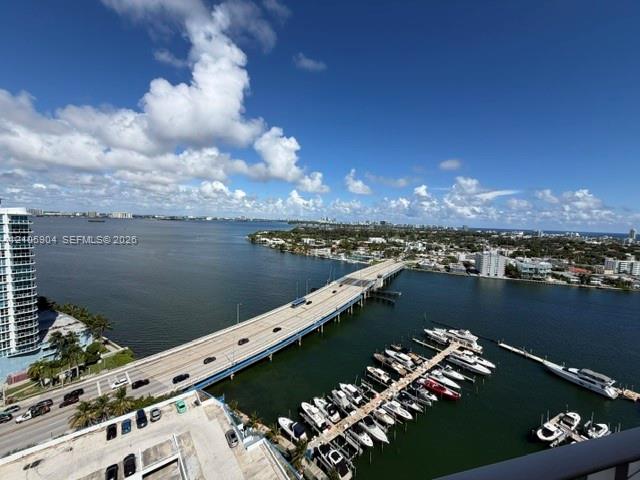 Elevated water scenery featuring a marina with docking slips, an expansive waterway, and bridge infrastructure Elevated water scenery featuring a marina with docking slips, an expansive waterway, and bridge infrastructure