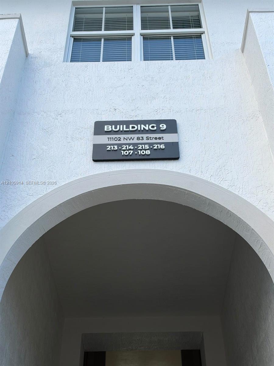 Stucco exterior featuring a prominent architectural archway and multi-pane window