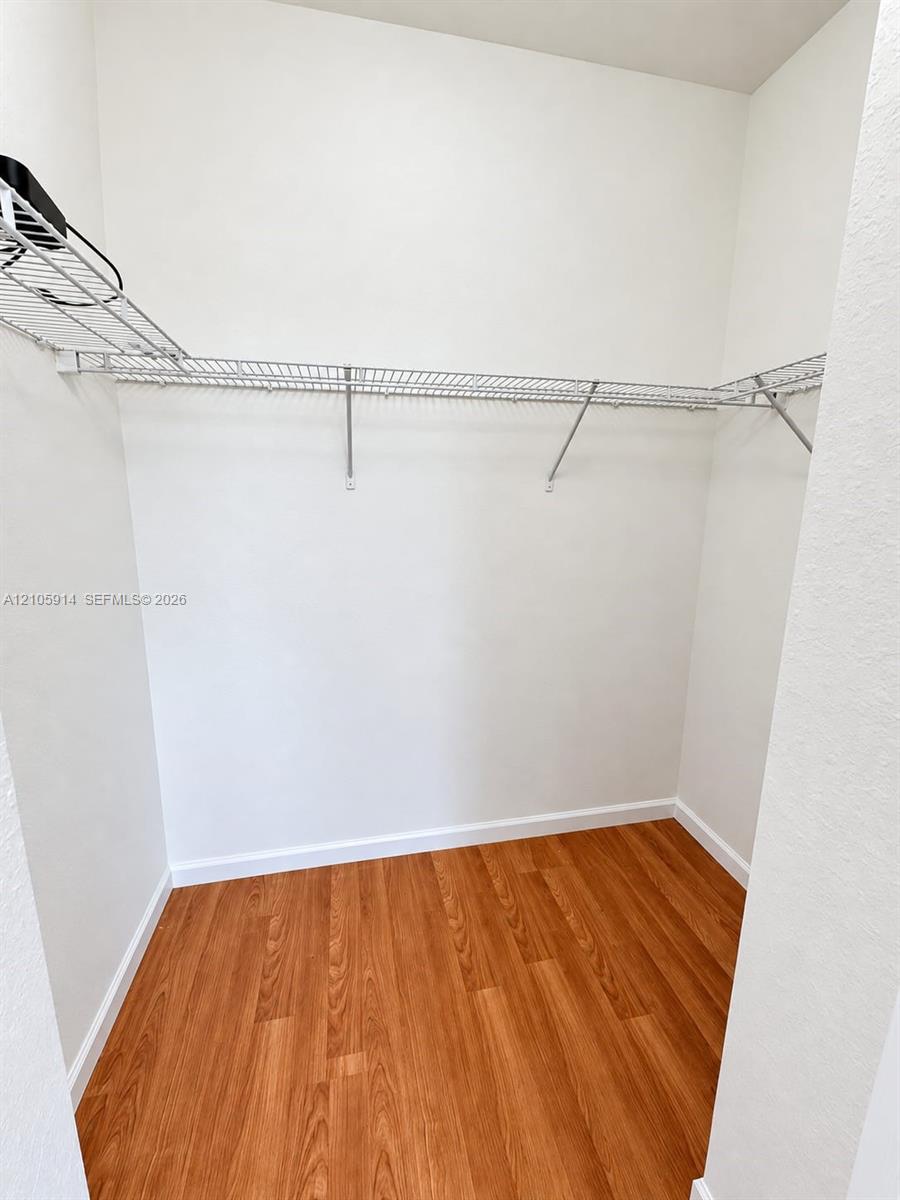 Storage area featuring wood-finish flooring and integrated wire shelving