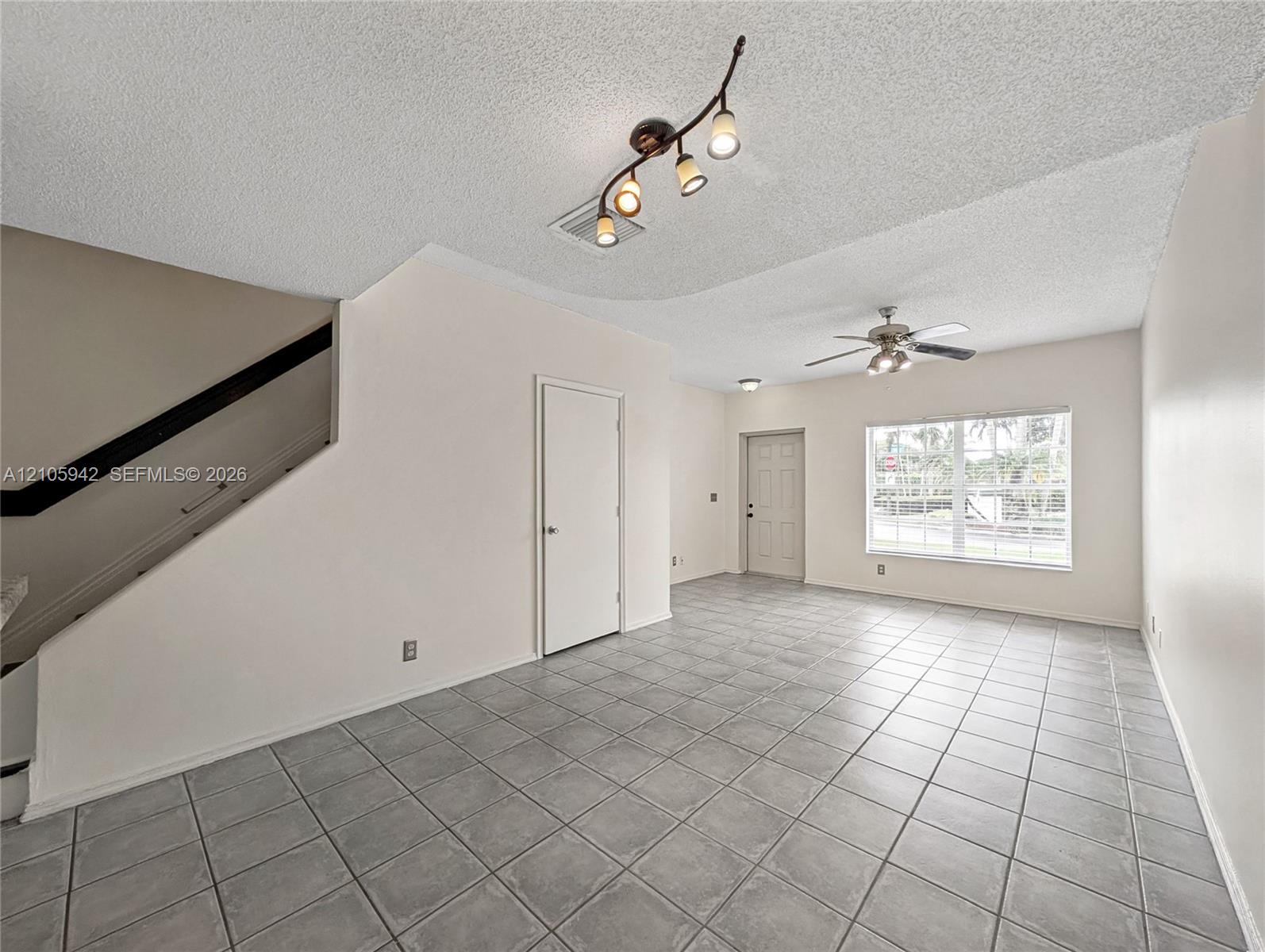 living ceramic floor tile, vaulted ceilings, a ceiling fan with integrated lighting