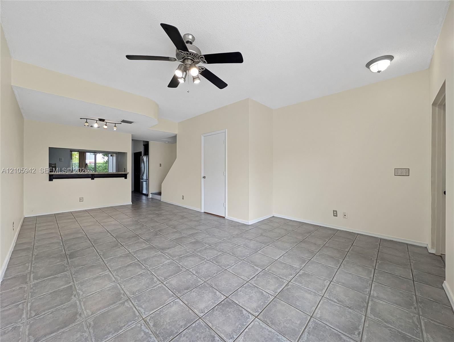 living ceramic floor tile, vaulted ceilings, a ceiling fan with integrated lighting