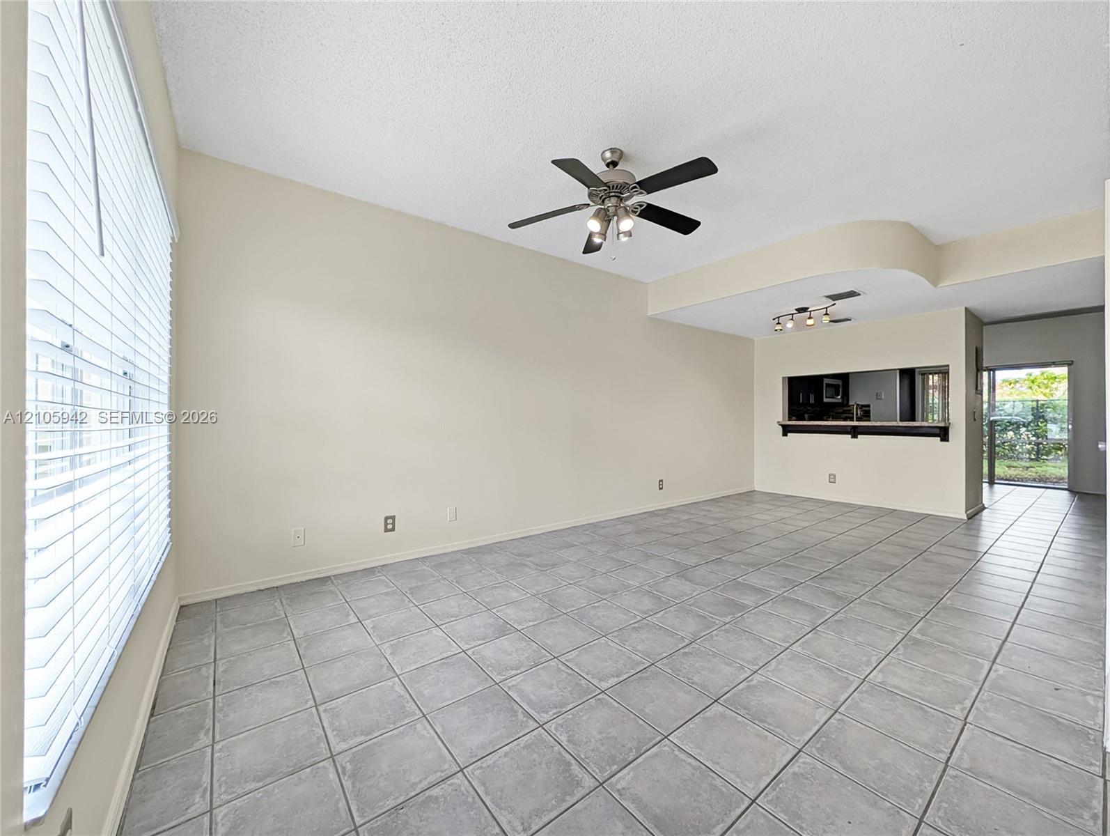 living ceramic floor tile, vaulted ceilings, a ceiling fan with integrated lighting