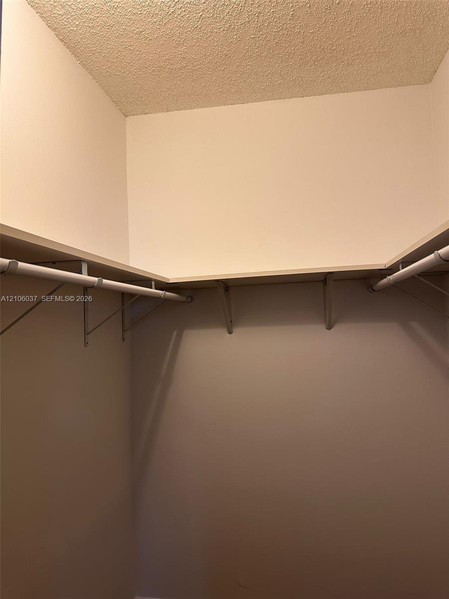 Storage area featuring wrap-around shelving and mounted clothing rods