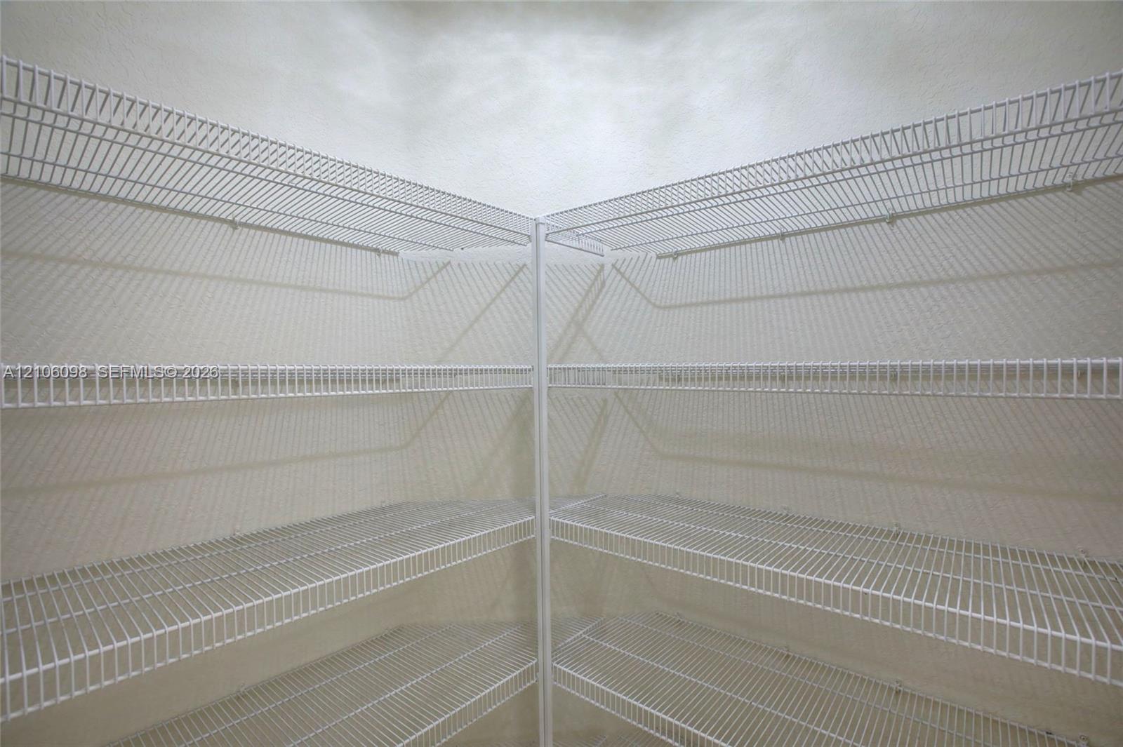 Corner storage area featuring white wire shelving across four tiers