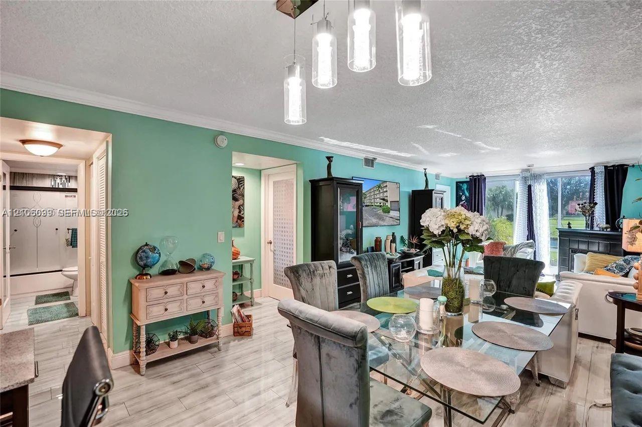 Open-concept area featuring tile flooring, crown molding, modern multi-pendant lighting, and sliding glass doors
